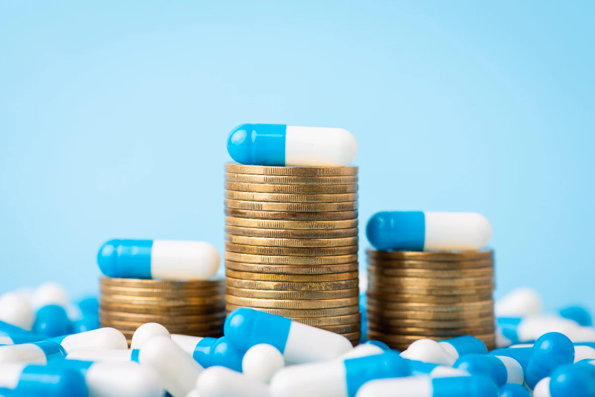 Pills on top of & around stacked coins - Featured image for blog post Partnering with a Fiduciary PBM is a No-Brainer