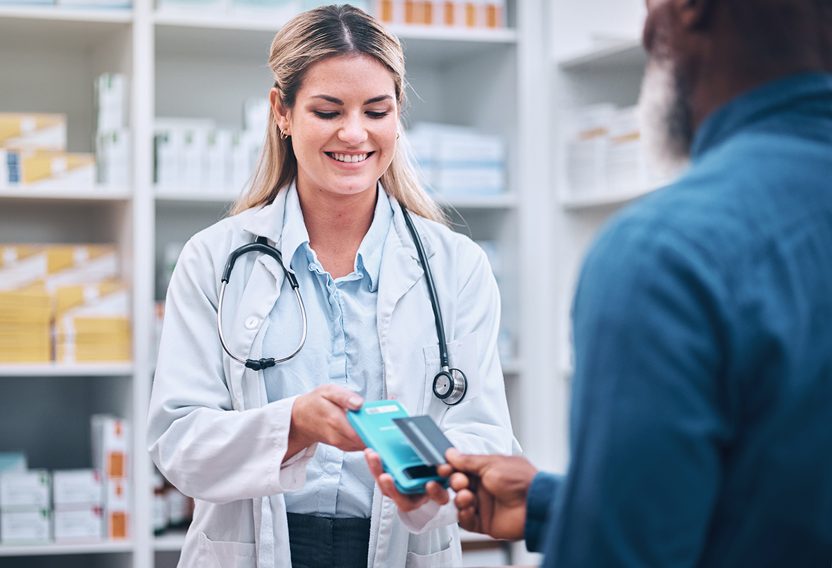 A pharmacist handing medication to a customer